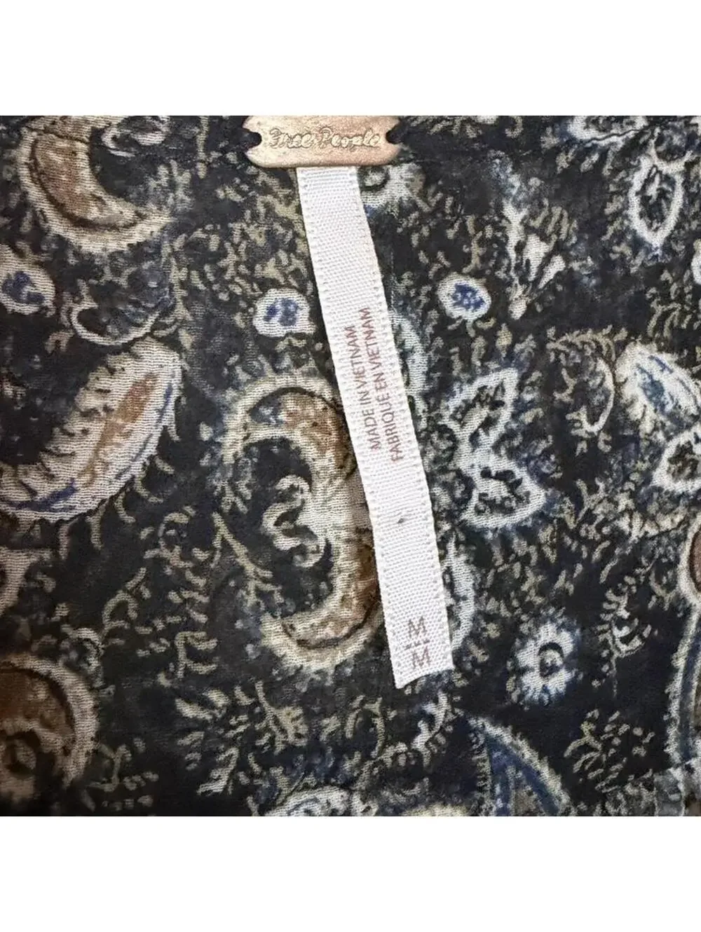 Black and grey paisley print blouse with long sleeves and ruffled hem